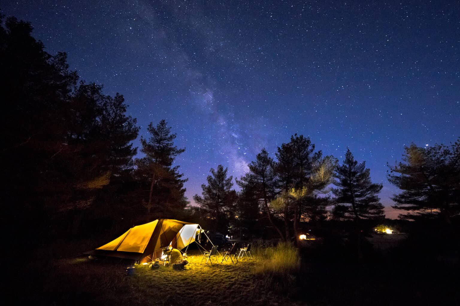 Tent lit from inside beneath the Milky Way
