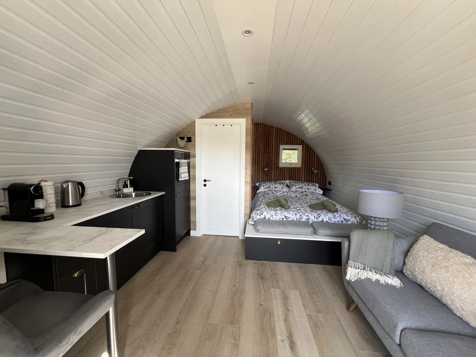 Inside the Emily Pod, with the kitchenette, sofa and king size bed