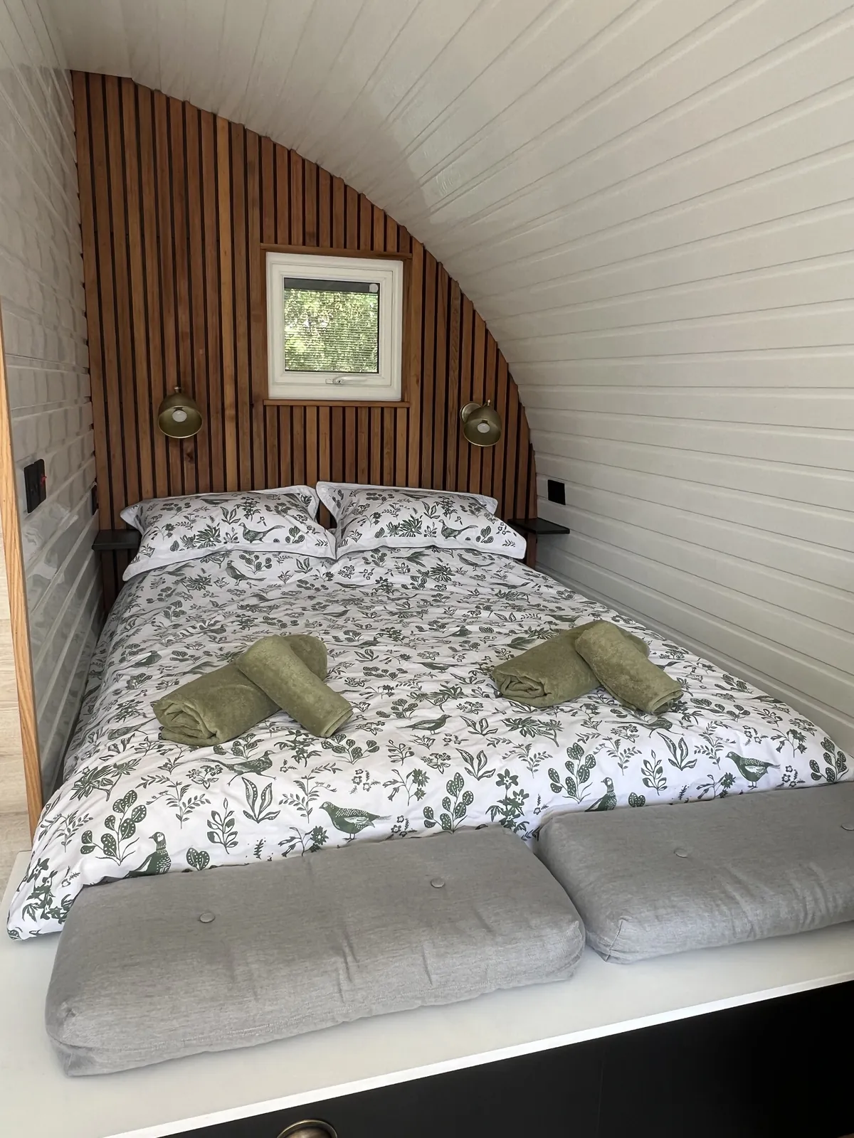 King size bed with bed linen and towels in the Emily Pod