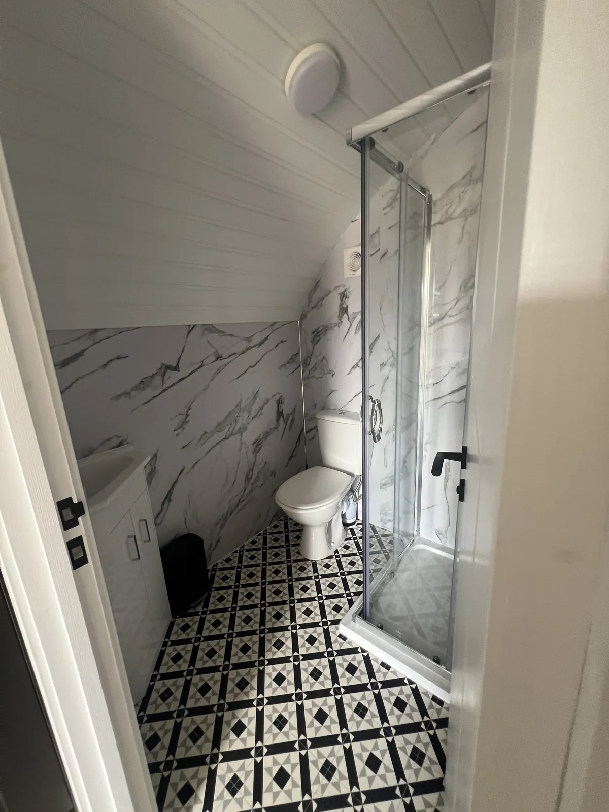 Emily Pod shower room with toilet and patterned floor tiles